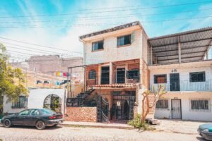 Independent House in Ramamurthy Nagar A picturesque residential street featuring charming vintage houses and a parked car under a clear blue sky.